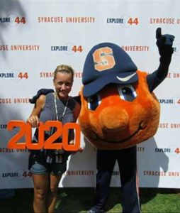 Inclusive U student Megan poses with Otto the Orange holding a class of 2020 sign